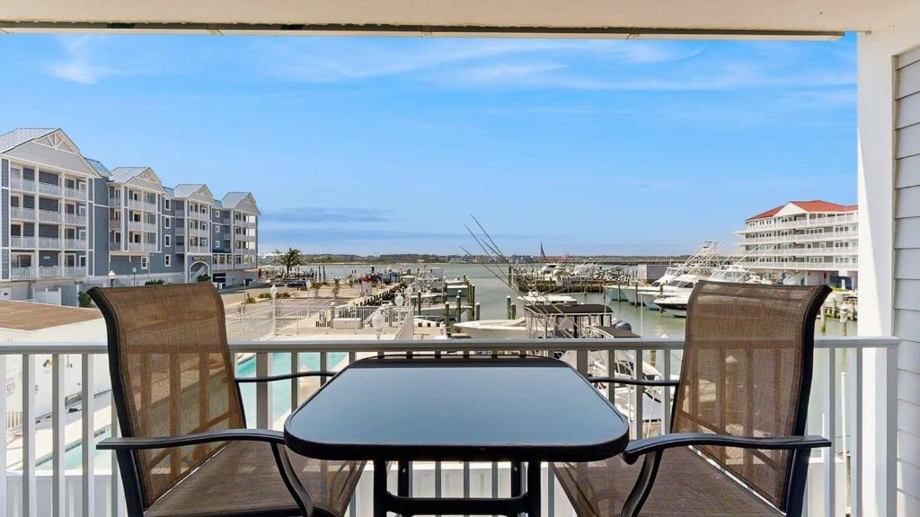 a table and chairs on a balcony with a marina at White Marlin 105B in Ocean City