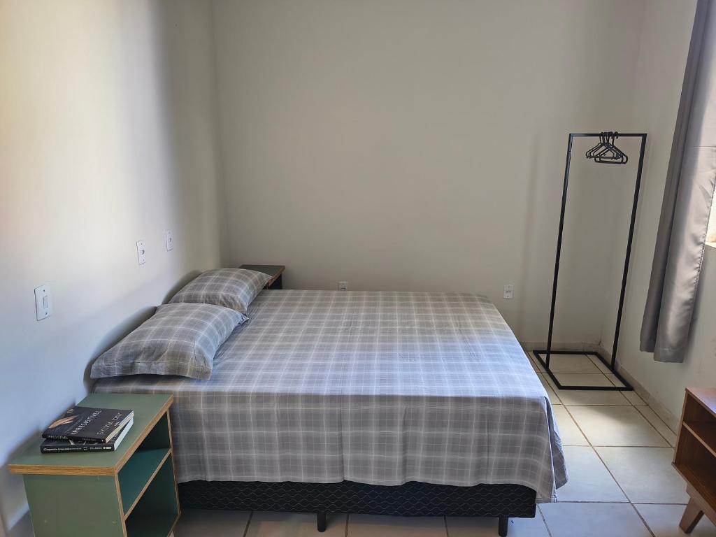 ein Schlafzimmer mit einem Bett und einem Nachttisch mit einem Bett sidx sidx sidx sidx in der Unterkunft Kitnet NOMAD in Barão de Cocais
