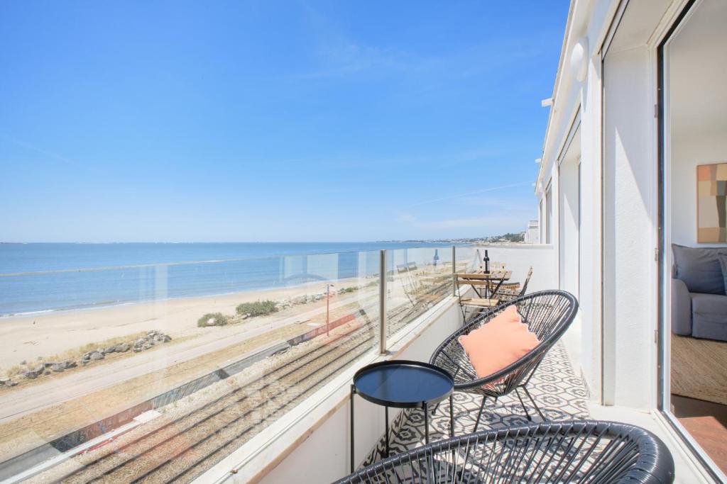 a balcony with two chairs and a view of the beach at Dreamy Sea View Balcony in Algés