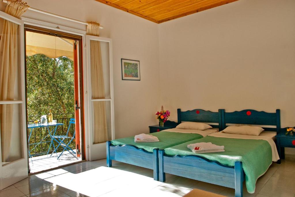 a bedroom with two beds and a sliding glass door at Trifilli in Lourdata