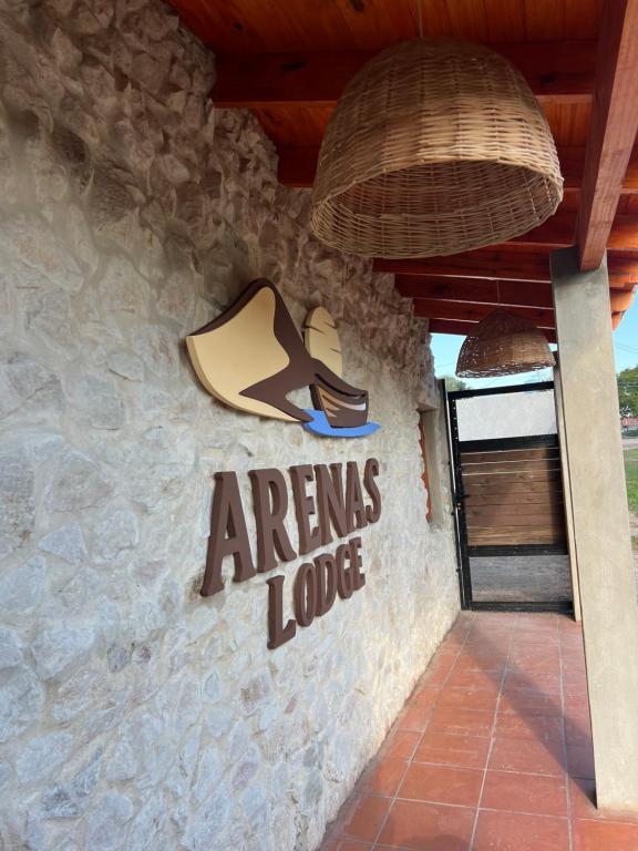 a sign on the side of a building with a sign on it at Arenas Lodge Hotel in Esquina