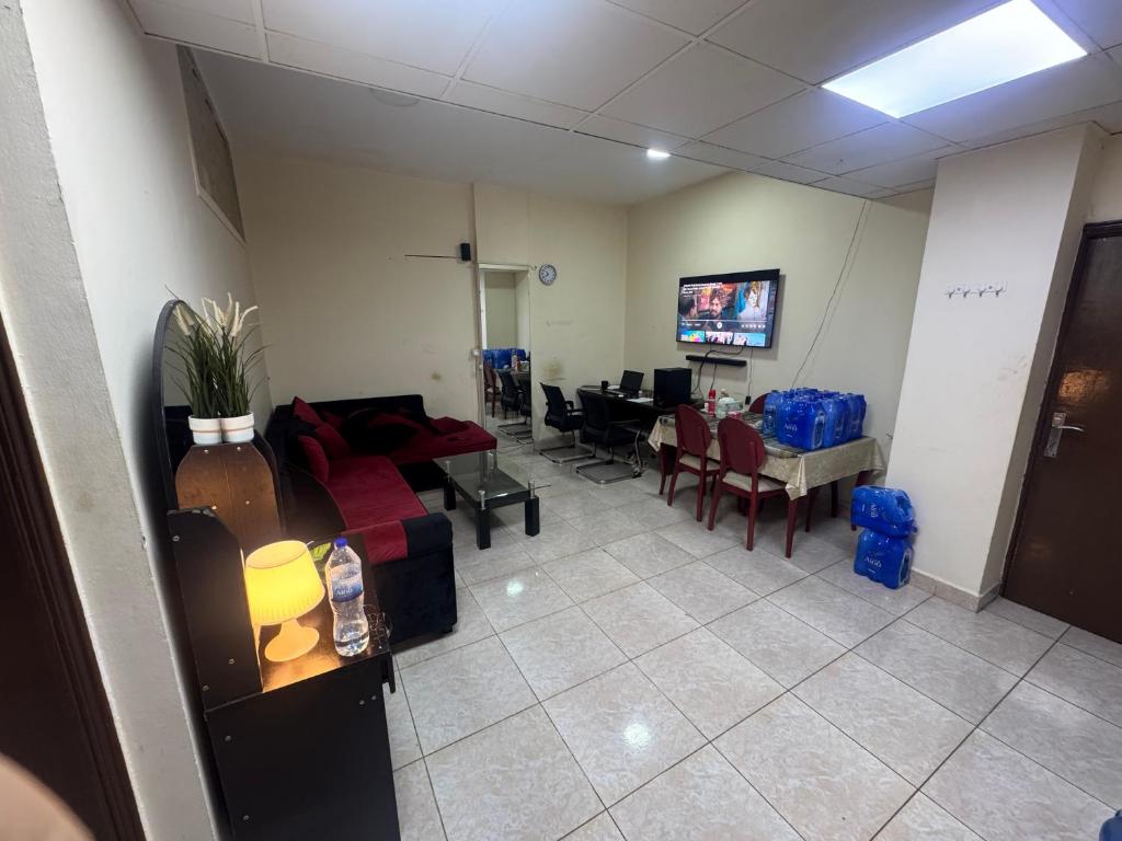 a waiting room with a couch and a table at 1 BHK Flat in Sharjah