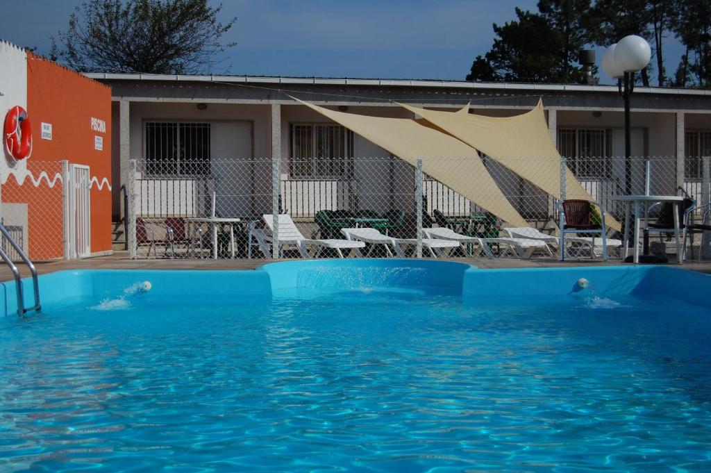 a swimming pool with blue water in front of a house at Hotel París in Poio