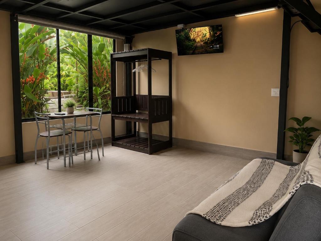 a living room with a bed and a table and chairs at IkI Volcán Arenal #2 in Fortuna