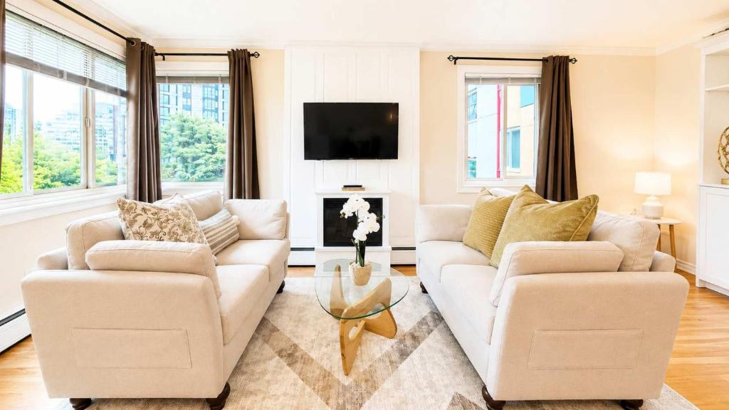 a living room with two couches and a tv at Downtown 1 BR Condo near Convention Center in Seattle