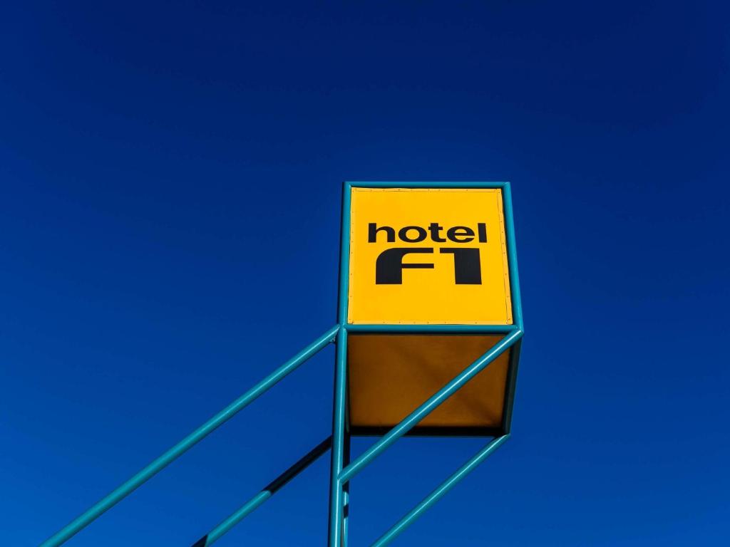 a sign for a motel f installed on top of a building at hotelF1 Annemasse Hotel Renove in Saint-Cergues
