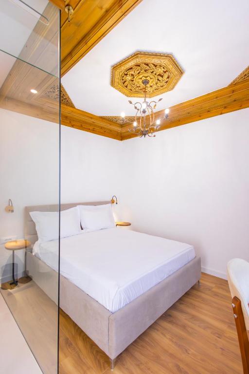 ein Schlafzimmer mit einem Bett mit Glaswand in der Unterkunft Vila Violet Berat in Berat
