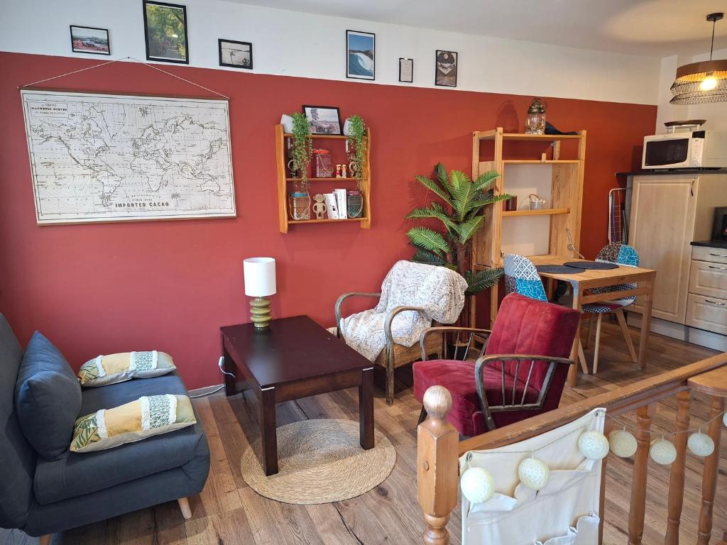 a living room with red walls and chairs at Duplex au coeur d'Embrun in Embrun