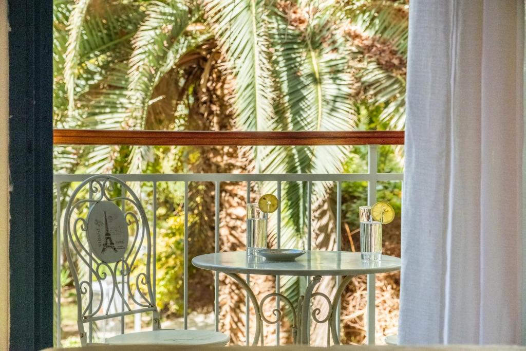 a table on a balcony with a palm tree at Royal Park Apartments Resort by Sea N Rent in Eilat