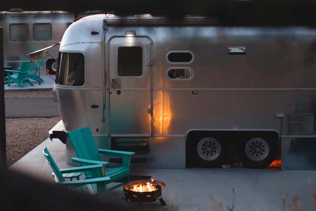 two chairs and a fire in front of an rv at Airstream Dream in Orderville