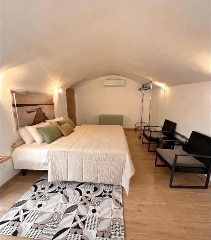 a bedroom with a bed and a chair and a desk at Casa Vacanza Pietre & Cielo in Ceglie Messapica