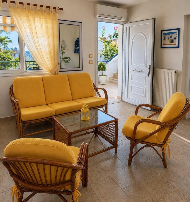 a living room with a couch and chairs and a table at SunsetApartment in Siviri
