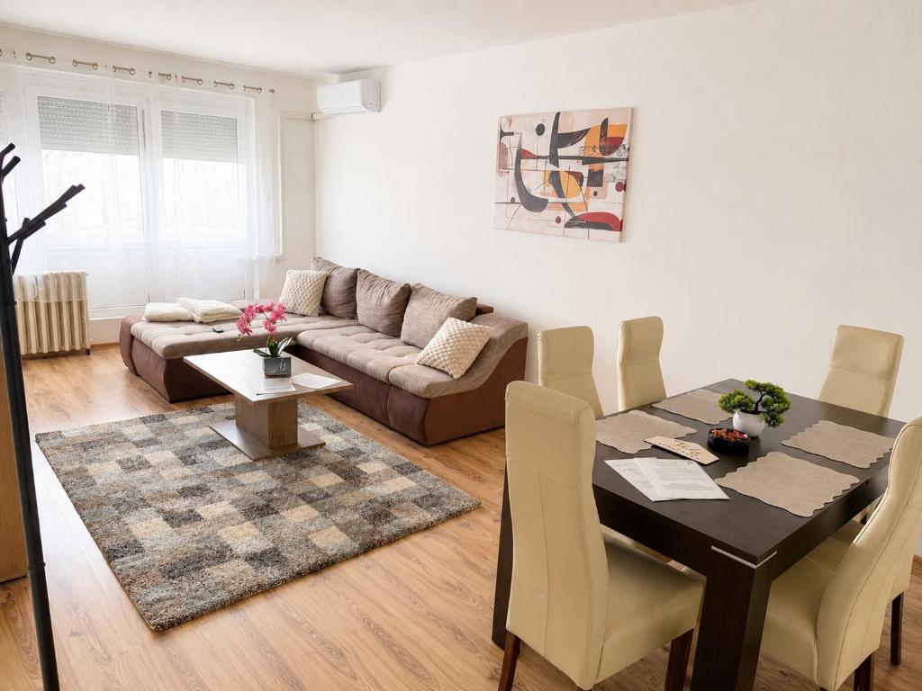 a living room with a table and a couch at Tildy Apartman Pécs in Pécs