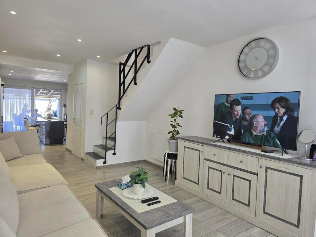 a living room with a couch and a clock on the wall at Maison Élégante - Space & Comfort Vilvoorde in Vilvoorde