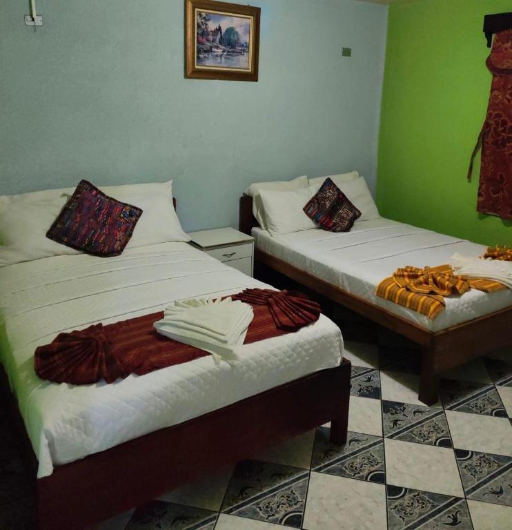 two beds in a room with green walls at Apartamento el Amigo in Panajachel