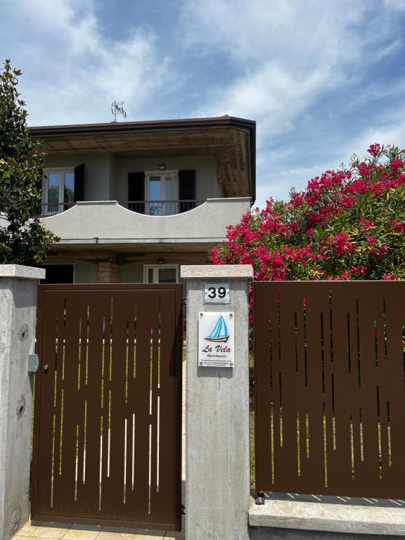 a house with a gate with a sign on it at La Vela in Sirmione
