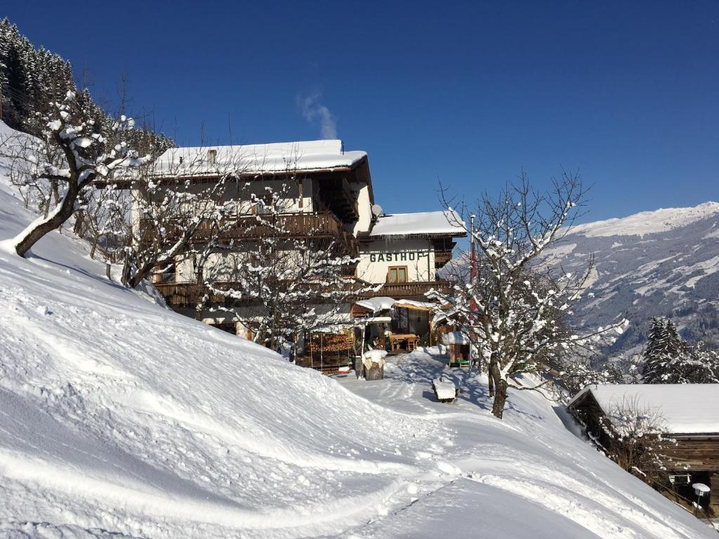 a snow covered building on a snow covered mountain at Gasthof Pension Berghof in Hippach