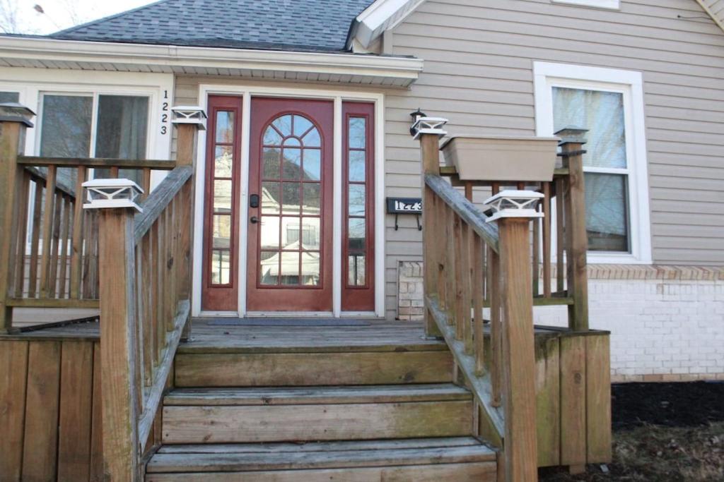 a wooden staircase leading to a house with a red door at The Polished Plank in Kokomo