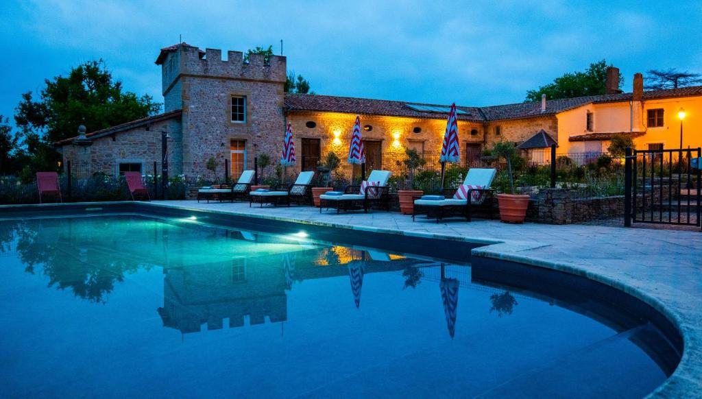 a house with a swimming pool in front of a building at Luxury Gites de Chateau Mirabel - Latour - with saltwater swimming pool and AC in Puylaurens