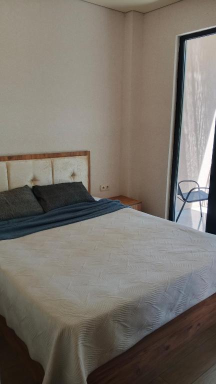 a bedroom with a large white bed with a window at Ureki Sun Estate in Ureki