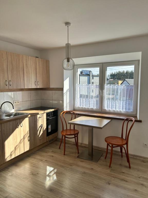 a kitchen with a table and two chairs in it at Królewska Przystań in Kamienica Królewska