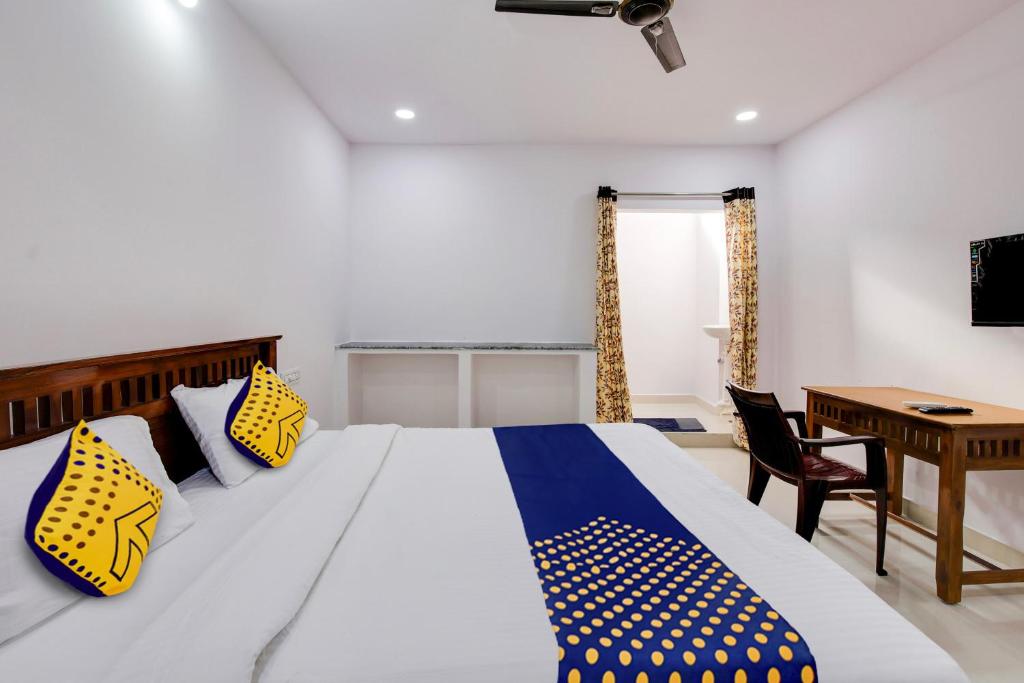 a bedroom with a bed with yellow and blue pillows at Hotel O Hills Land in Warangal