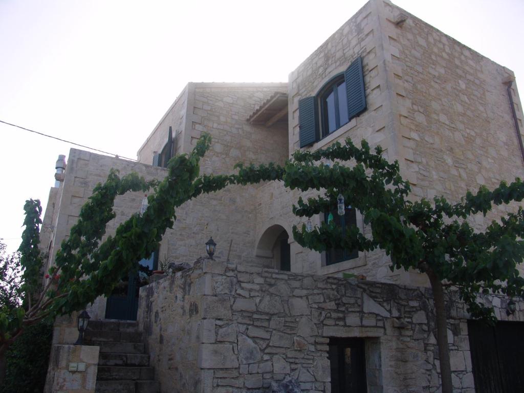 un edificio con un árbol delante de él en Villa Aloni, en Margarítai