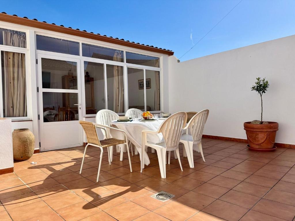 a white table and chairs on a patio at La terraza del Campanario in Ríolobos