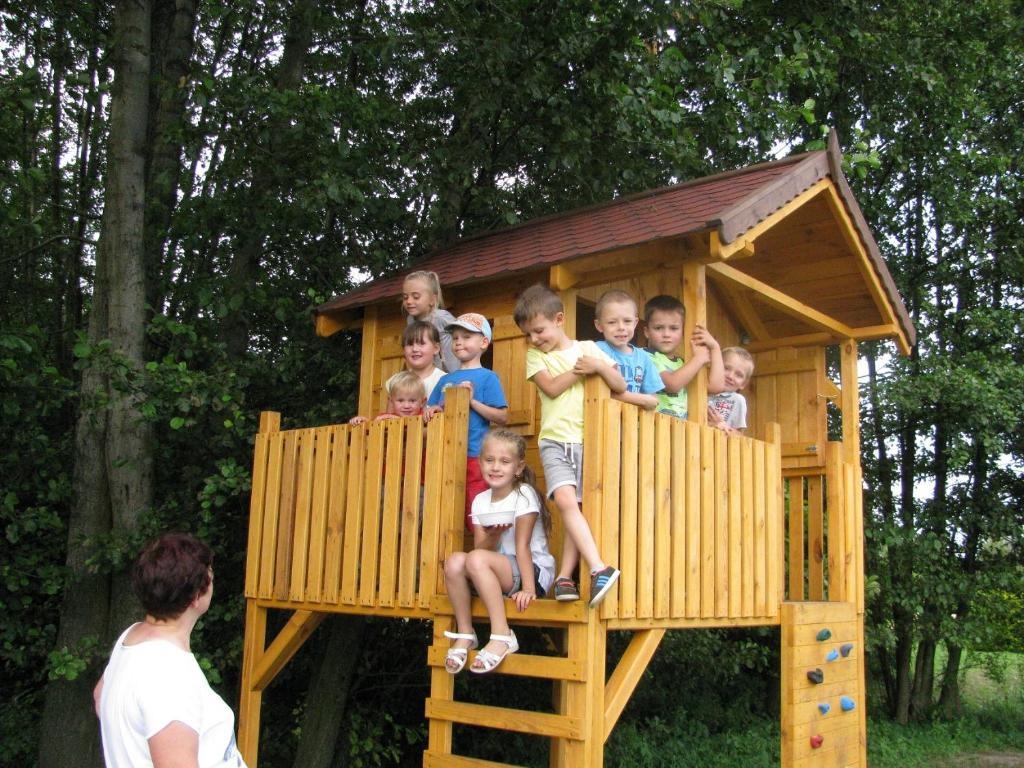 un grupo de niños sentados en una casa de juegos en Agroturystyka Borówka, en Mały Dólsk