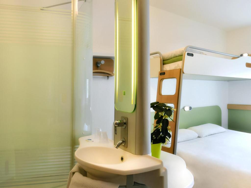 a bathroom with a sink and a bunk bed at ibis budget Saint-Quentin Centre Gare in Saint-Quentin