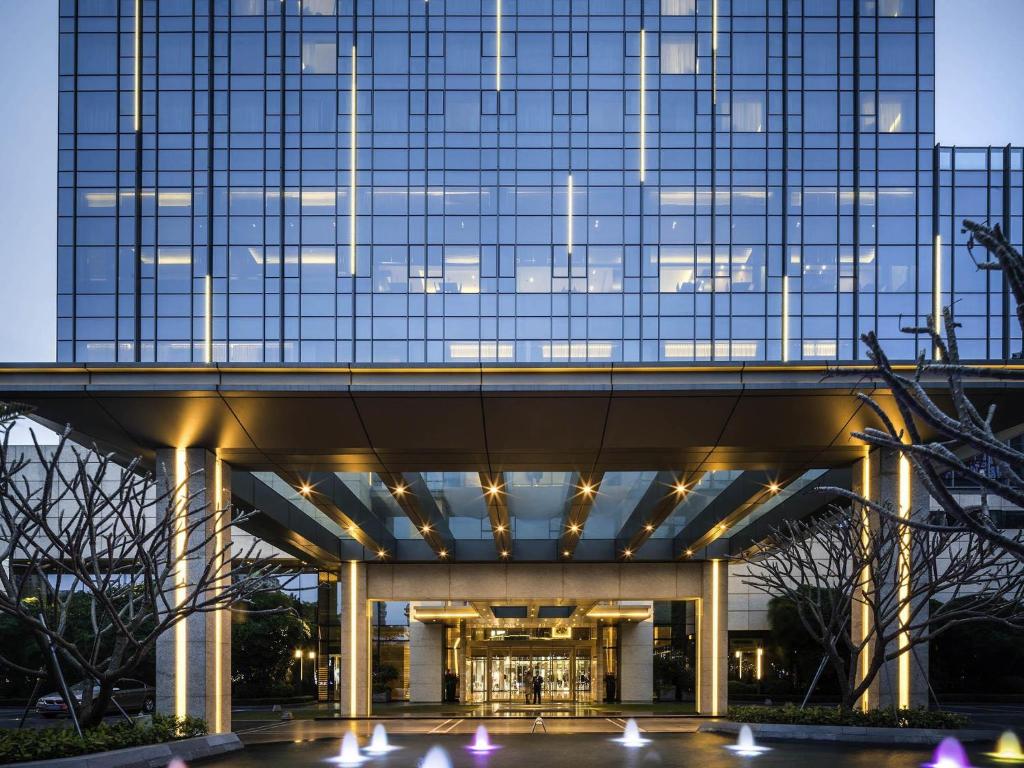 a tall building with lights in front of it at Pullman Zhuhai in Zhuhai