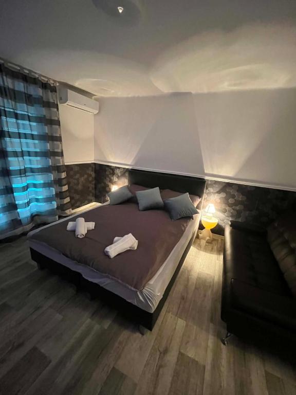 a bedroom with a bed with two towels on it at Willow Apartmant in Harkány