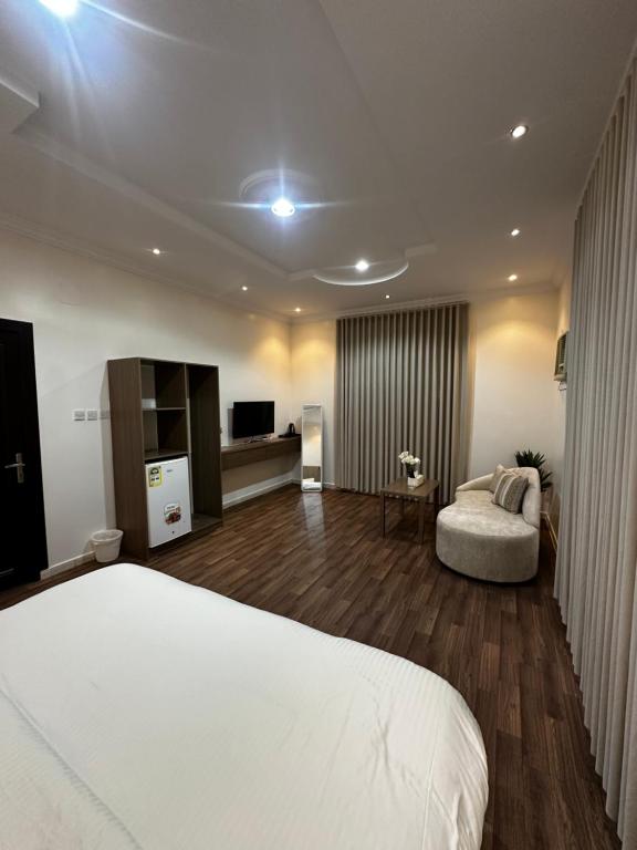 a bedroom with a white bed and a couch at غرف خاصة مودرن in Hail