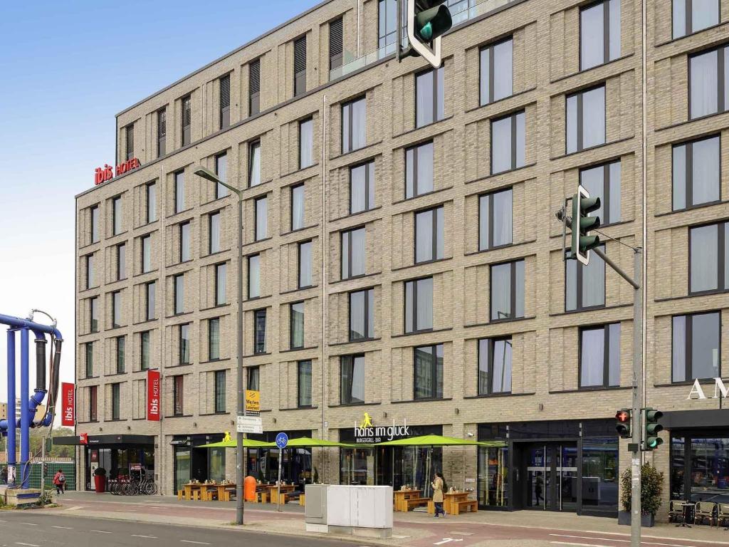 a large brick building on a city street with a traffic light at Ibis Berlin Hauptbahnhof in Berlin