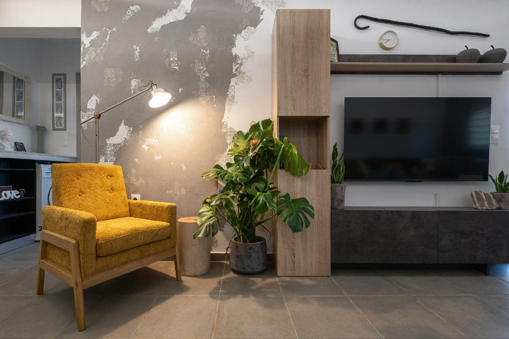 a living room with a yellow chair and a tv at Villa Theros in Ierapetra