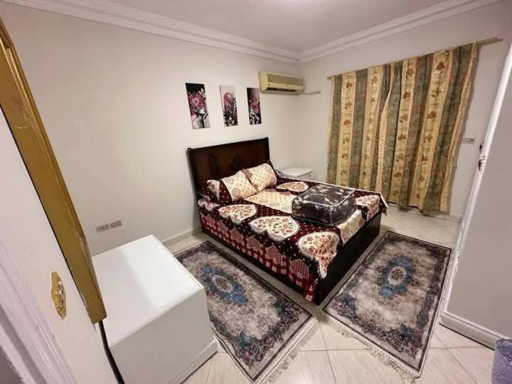 a bedroom with a bed and two rugs at Amr home in Amman