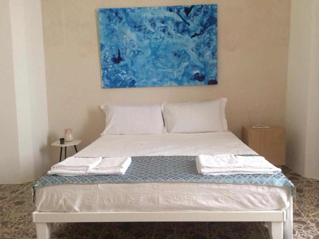 uma cama branca com duas toalhas em cima em Tolomeo's House-Bed & Bike em Nardò