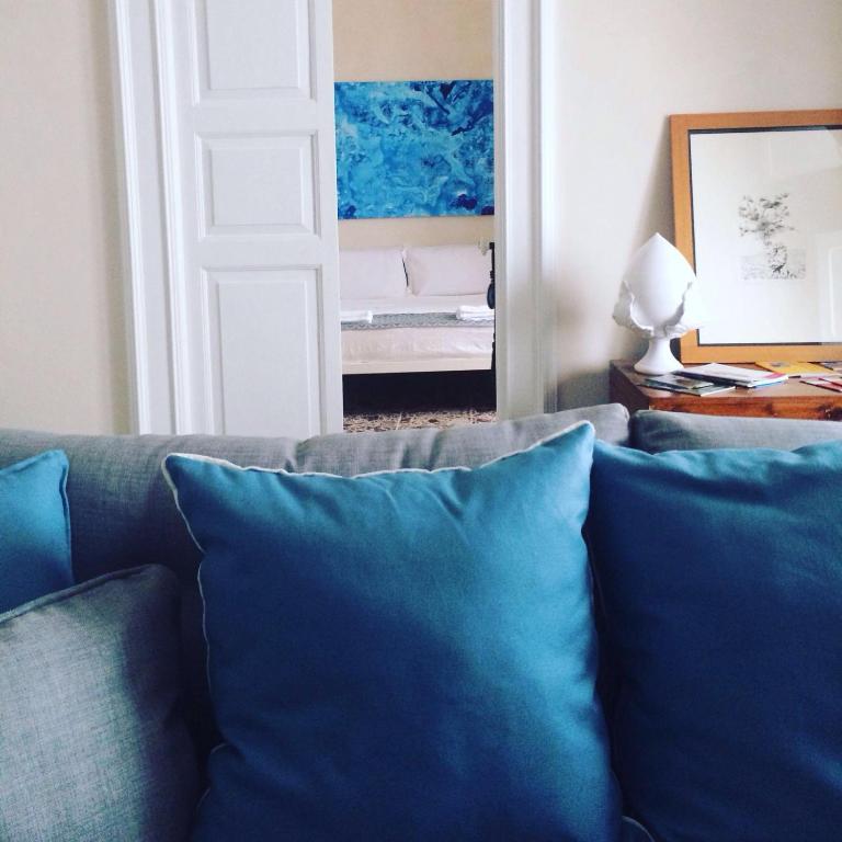 a living room with a couch with blue pillows at Tolomeo's House-Bed & Bike in Nardò