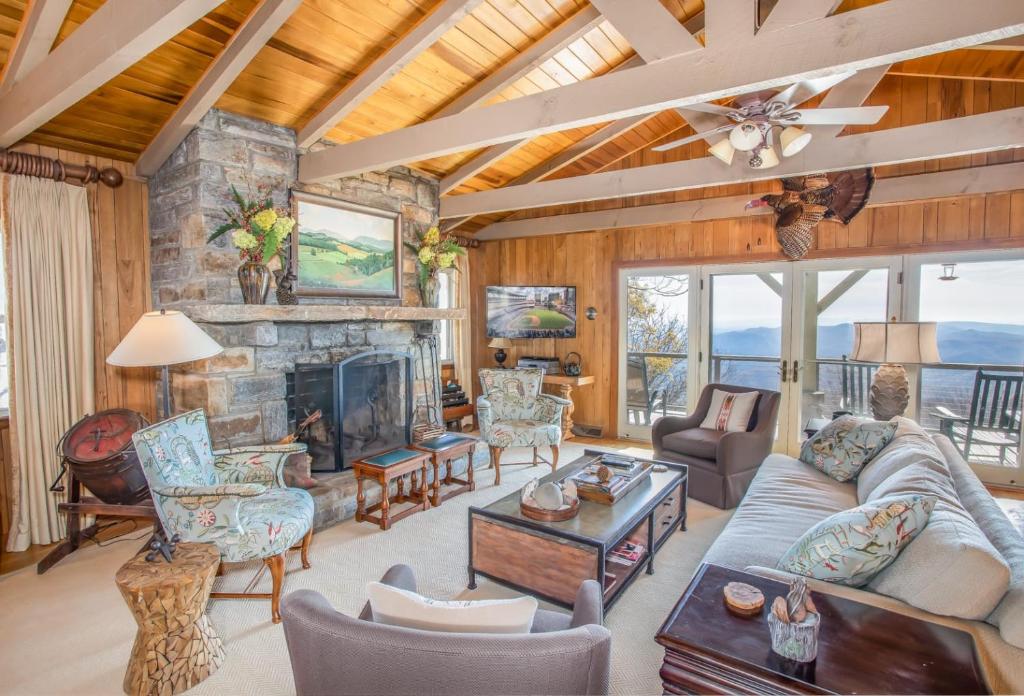 a living room filled with furniture and a stone fireplace at Out On A Limb in Blowing Rock