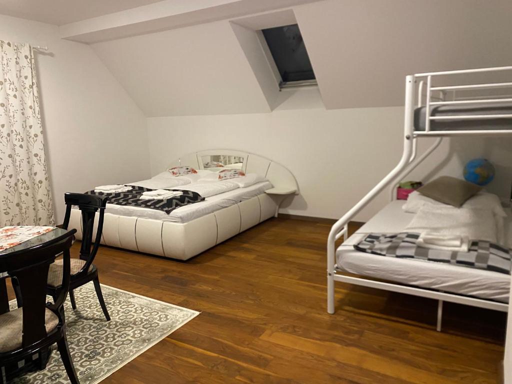 two beds in a room with a table and a chair at Apartment 2 in Neunkirchen