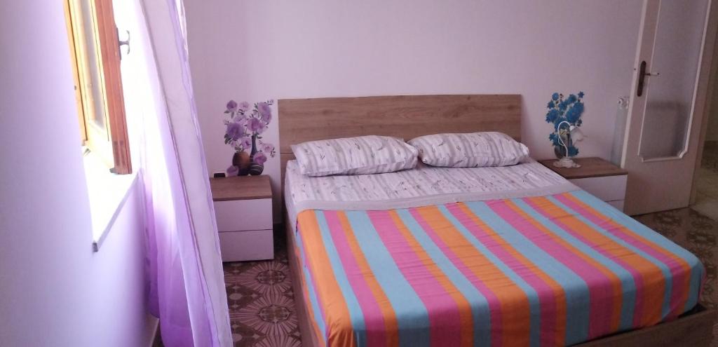 a bedroom with a bed with a colorful striped blanket at Villa Pina in Vico Equense