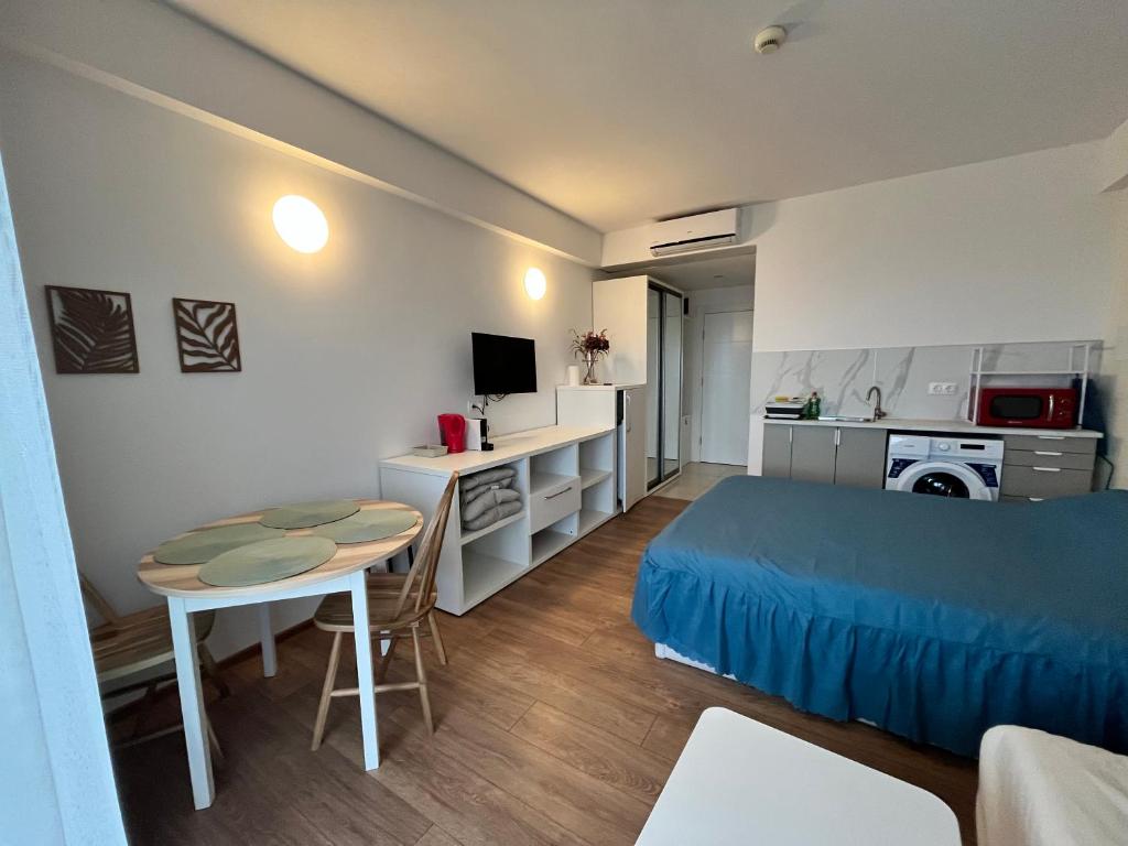a bedroom with a bed and a table and a desk at Studio Cris Sea View in Blaxy Residence in Douăzeci şi Trei August