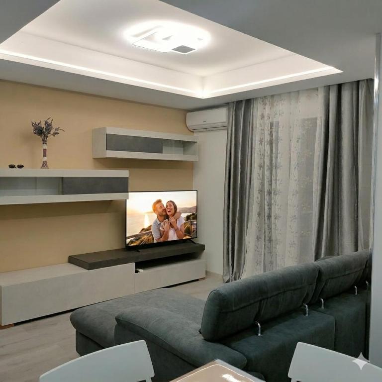 a living room with a couch and a flat screen tv at ANAMI' Suite Apartament in Bovalino Marina