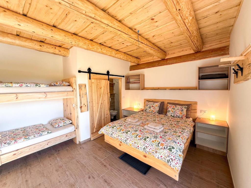 a bedroom with a bed and two bunk beds at Village Vista in Rob