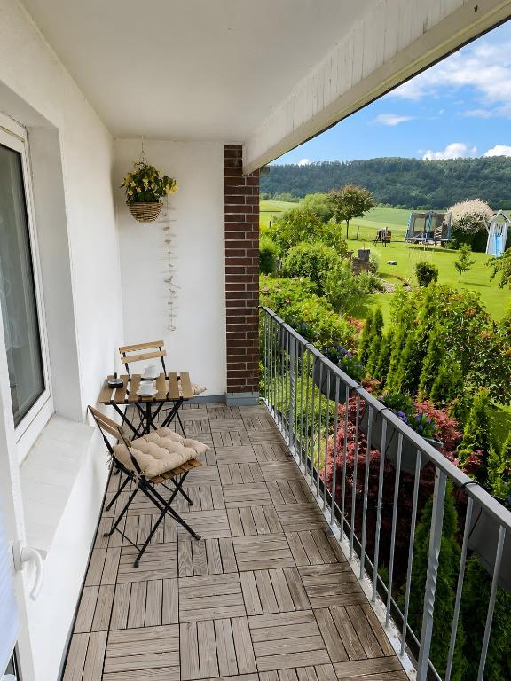 a balcony with a table and chairs and a view at Schöner Ith Blick in Salzhemmendorf