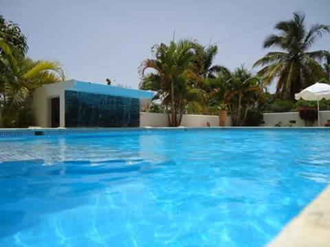 a large blue swimming pool in front of a building at Villa Victoria in Sosúa