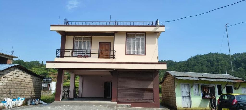 a house with a balcony on top of it at Townhouse Mylliem Formerly Infinity Bed & Breakfast in Shillong