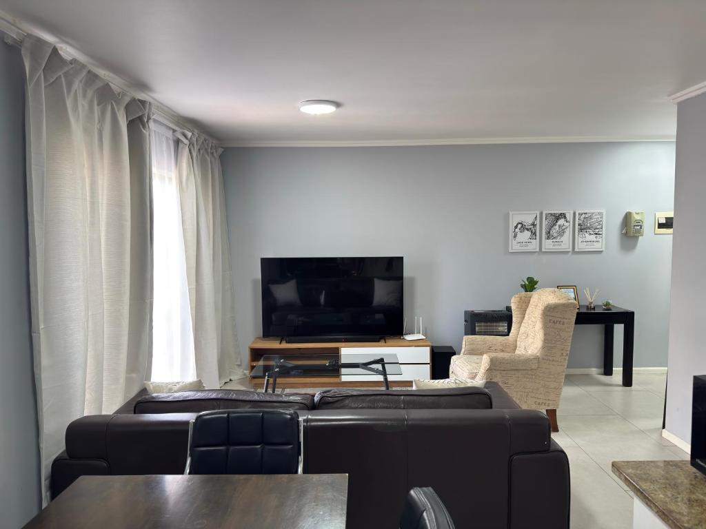 a living room with a couch and a tv at Blouberg Beach Gem 5 Min Walk in Cape Town