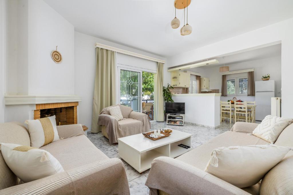 a living room with two couches and a fireplace at Casa Mia Skopelos - Spacious 3-Bedroom House near Stafylos Beach in Skopelos Town