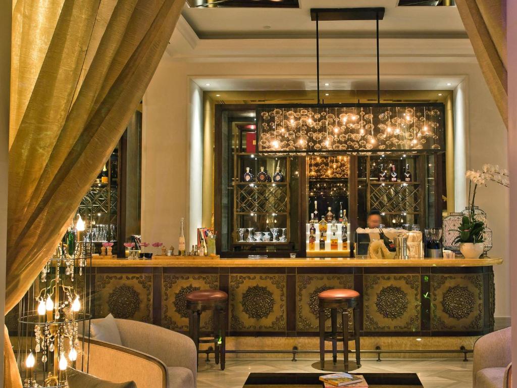 a bar with a lot of bottles of wine at Hotel Des Arts Saigon Mgallery Collection in Ho Chi Minh City